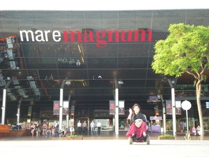 Lucia in carrozzina nell’area del Maremagnum a Barcellona